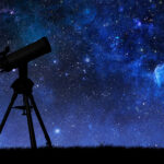 Telescope silhouette against the starry sky
